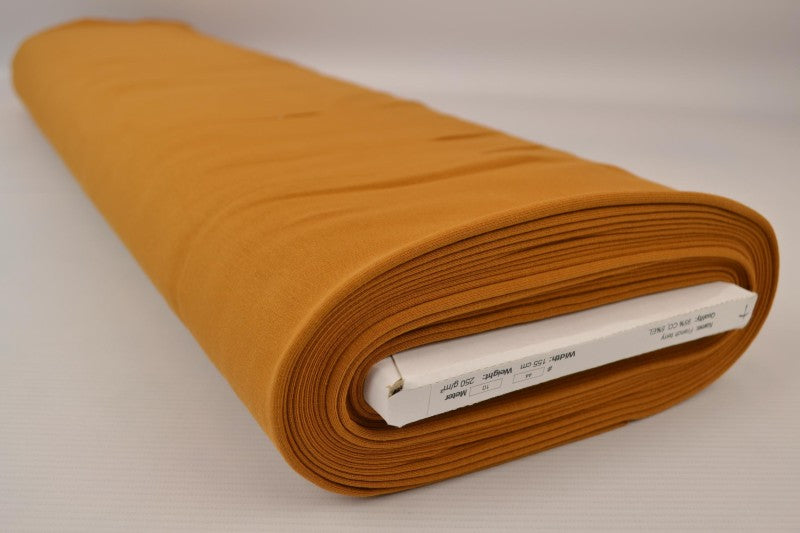 MÖRK OKERGUL FRENCH TERRY – MJUK BOMULLSSTICKAD METERVARA MED STRETCH